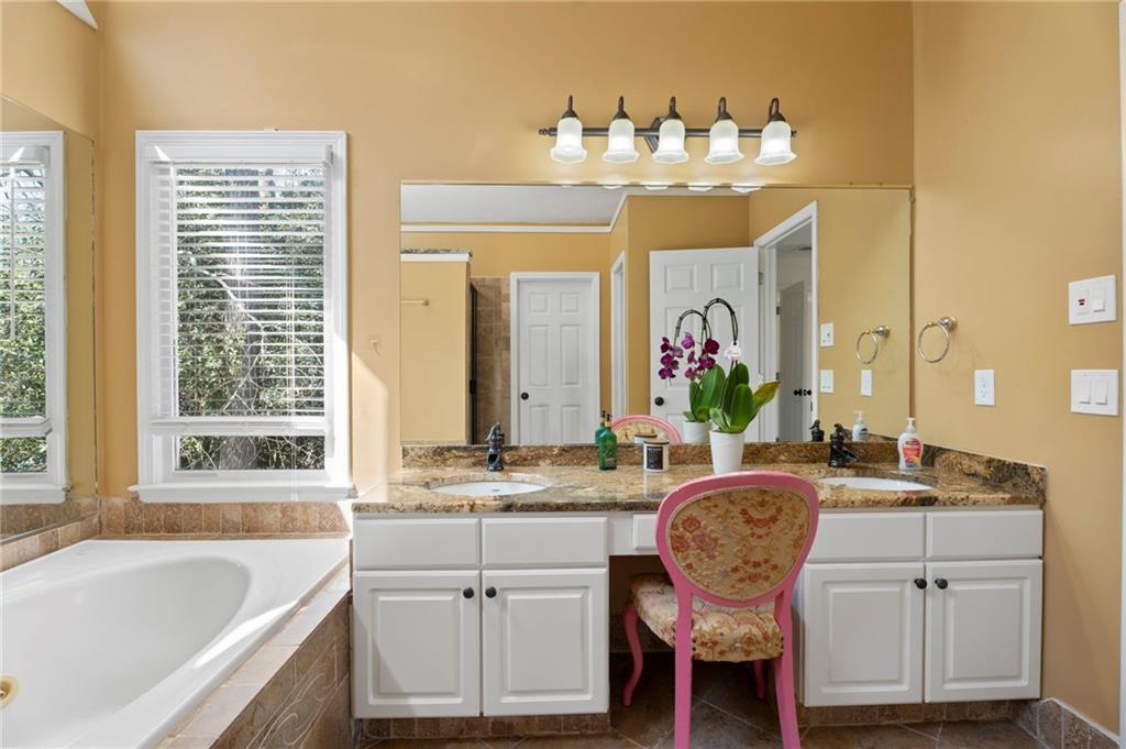 1381 Gateswalk Path Lawrenceville, GA 30045 - Photo 36 of 45 a bathroom with a granite countertop sink mirror and a bathtub