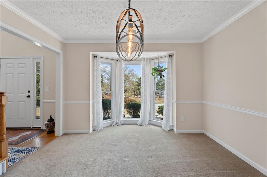 1381 Gateswalk Path Lawrenceville, GA 30045 - Photo 9 of 45 an empty room with chandelier fan and wooden floor