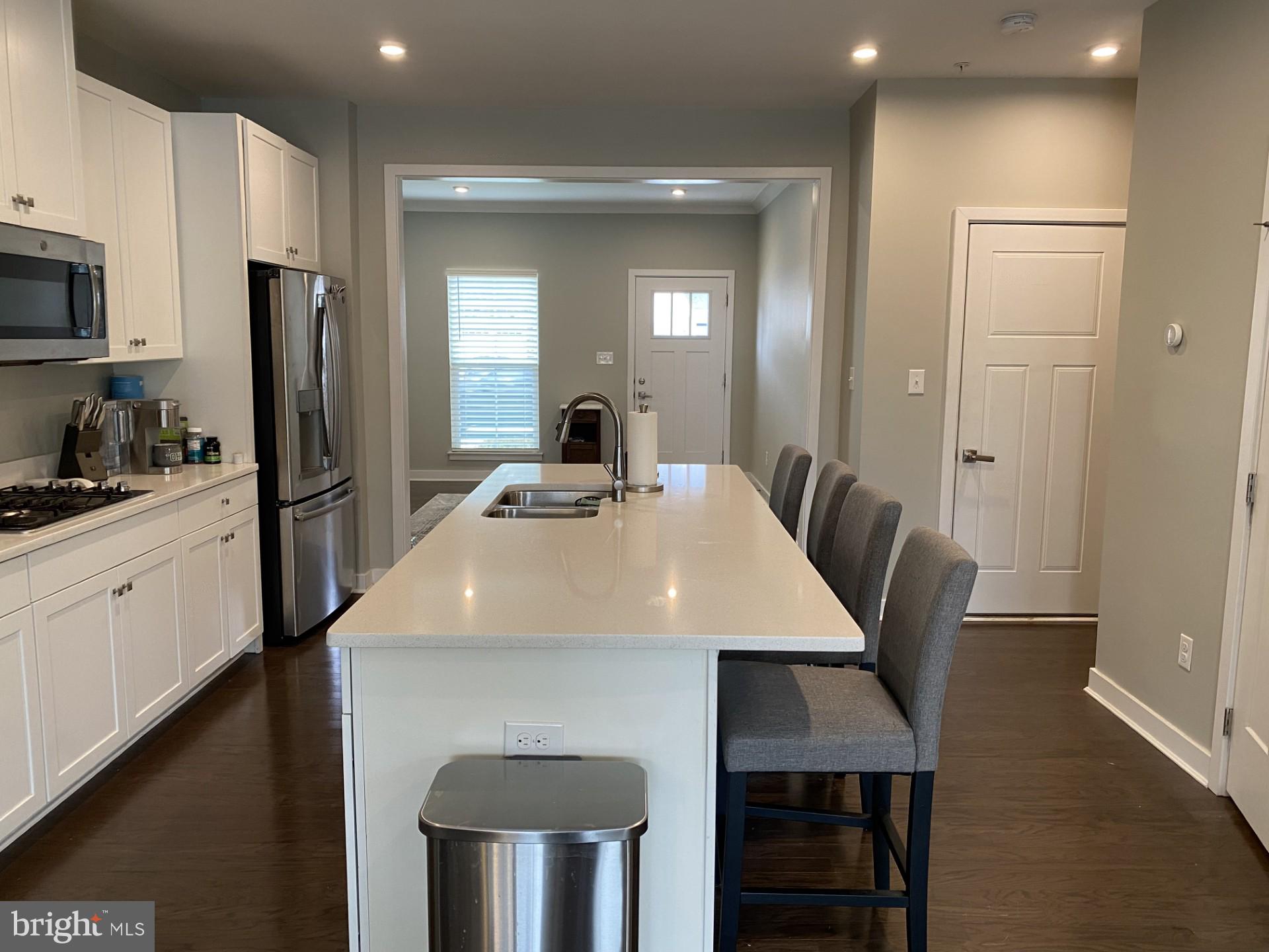 1214 Benjamin Drive Kennett Square, PA 19348 - Photo 5 of 34 a kitchen with a table chairs refrigerator and microwave