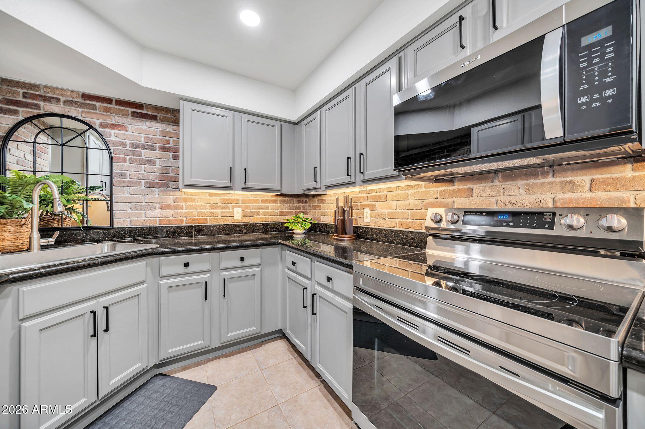 8787 East Mountain View Road, Unit 2038 Scottsdale, AZ 85258 - Photo 14 of 37 a kitchen with stainless steel appliances granite countertop a stove and a sink