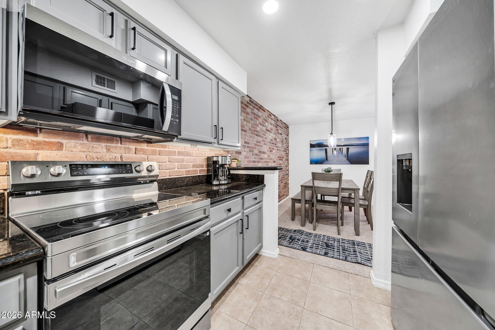 8787 East Mountain View Road, Unit 2038 Scottsdale, AZ 85258 - Photo 15 of 37 a kitchen with stainless steel appliances and chandelier