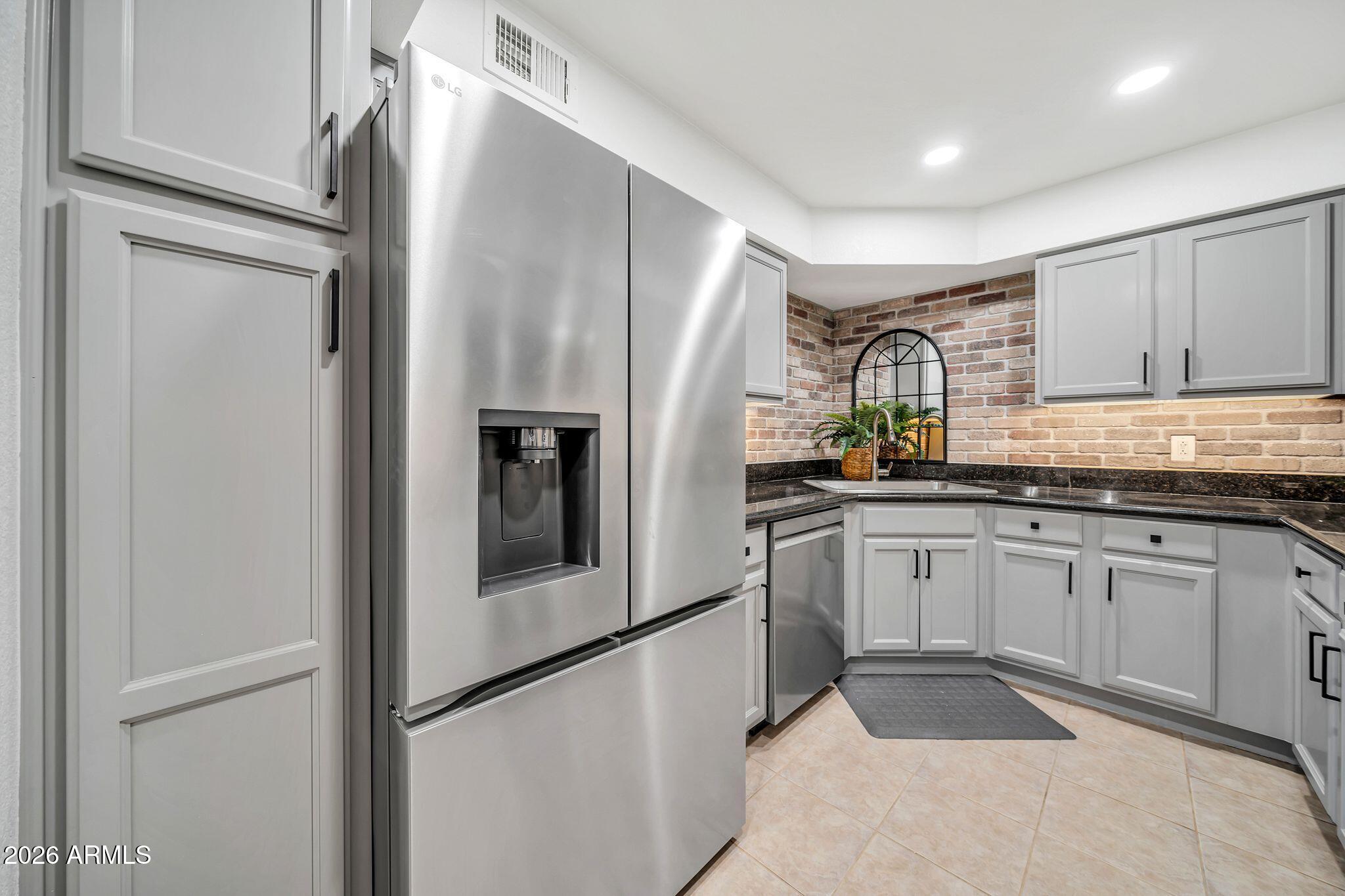 8787 East Mountain View Road, Unit 2038 Scottsdale, AZ 85258 - Photo 19 of 37 a kitchen with stainless steel appliances granite countertop a refrigerator and a sink
