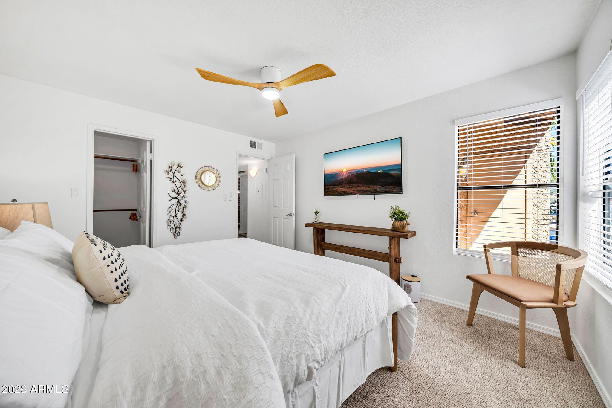 8787 East Mountain View Road, Unit 2038 Scottsdale, AZ 85258 - Photo 20 of 37 a bedroom with a bed and a flat screen tv