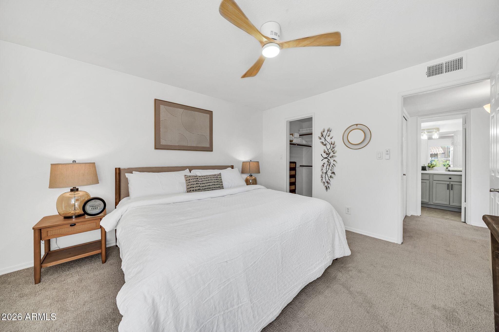 8787 East Mountain View Road, Unit 2038 Scottsdale, AZ 85258 - Photo 23 of 37 a spacious bedroom with a bed and a lamp