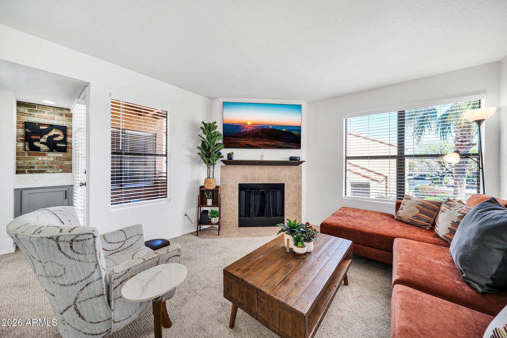 8787 East Mountain View Road, Unit 2038 Scottsdale, AZ 85258 - Photo 4 of 37 a living room with furniture a fireplace and a flat screen tv