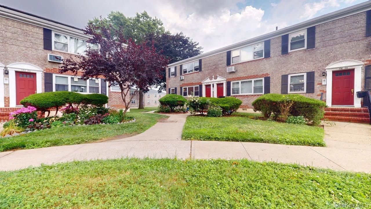 a front view of a house with a yard and outdoor seating