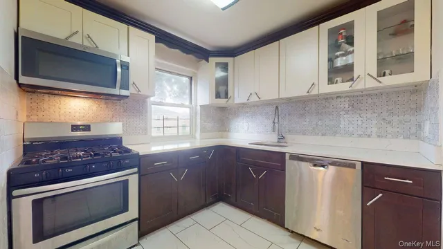 a kitchen with stainless steel appliances granite countertop a sink stove and microwave