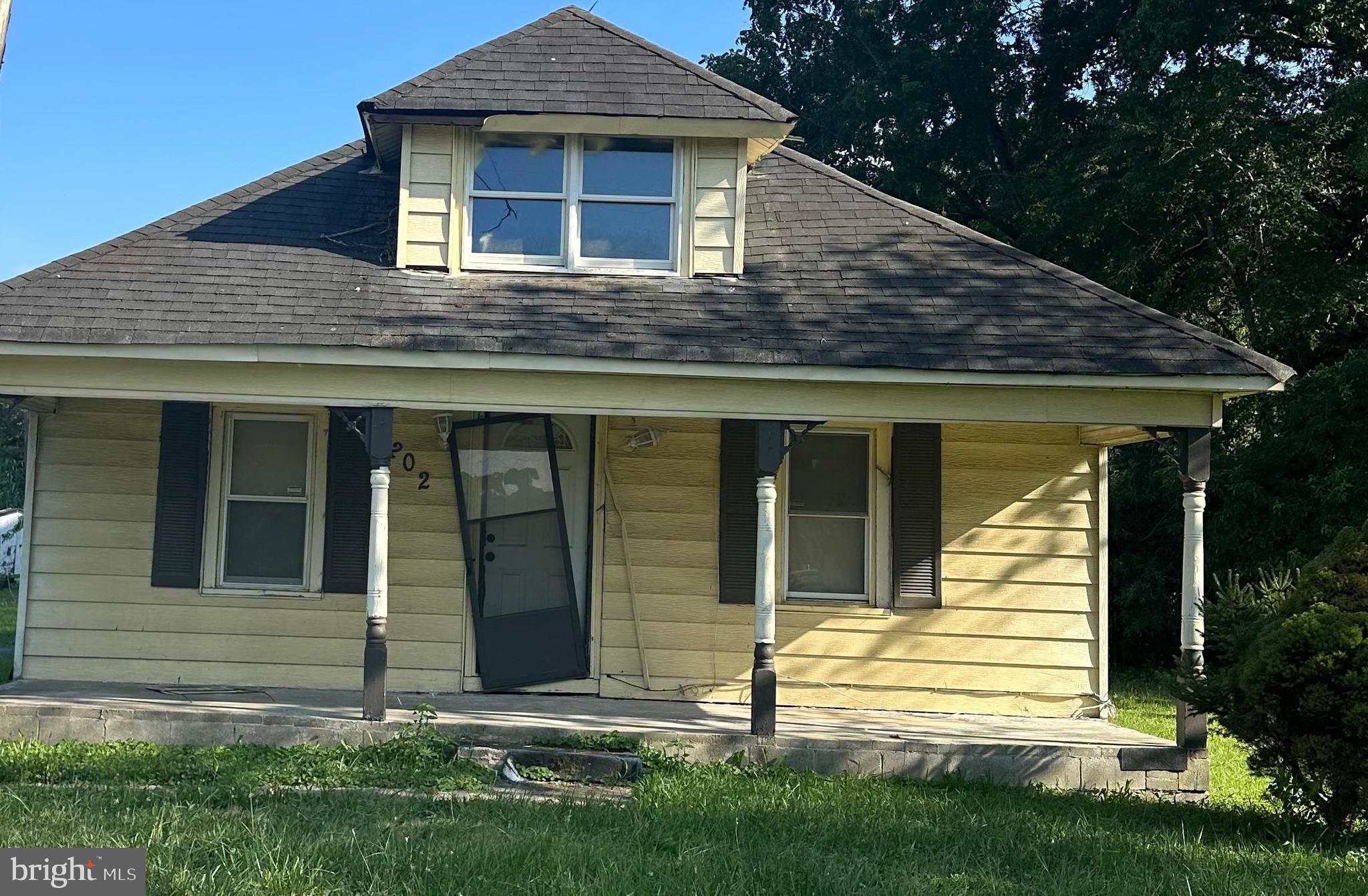 a view of a house with brick walls and a yard with plants