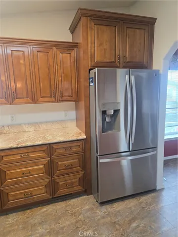 a kitchen with granite countertop a refrigerator and a sink