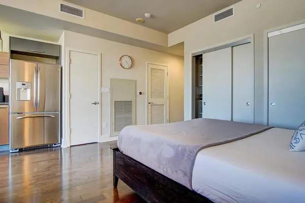 a bedroom with a bed and a refrigerator