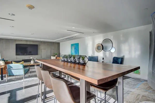 a living room with stainless steel appliances furniture and a large window