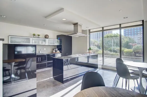 a kitchen with kitchen island stainless steel appliances a table and chairs
