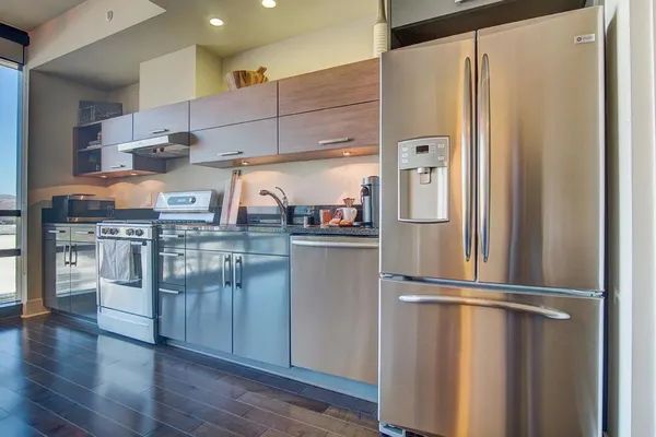 a kitchen with stainless steel appliances granite countertop a refrigerator and a stove top oven