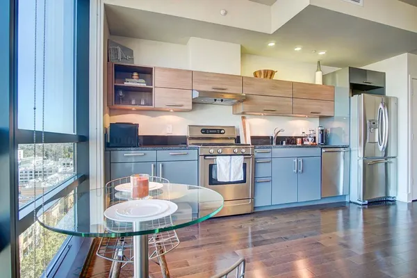 a kitchen with stainless steel appliances granite countertop a sink and a refrigerator