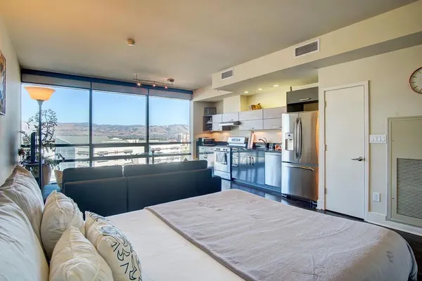a kitchen with a refrigerator a sink dishwasher a stove and a dining table with wooden floor