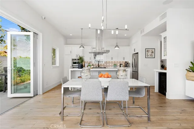 a dining room with stainless steel appliances kitchen island a table and chairs
