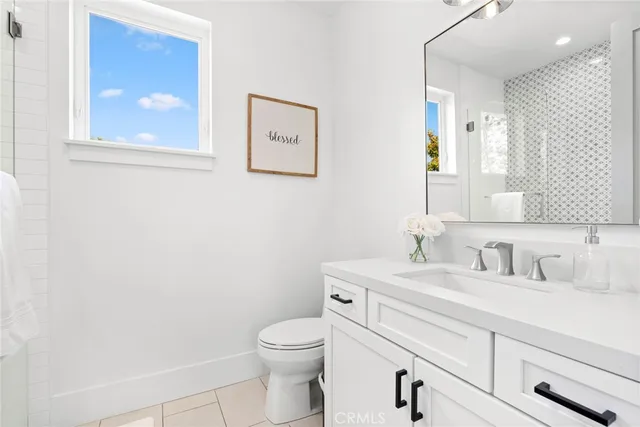 a bathroom with a toilet sink vanity and mirror
