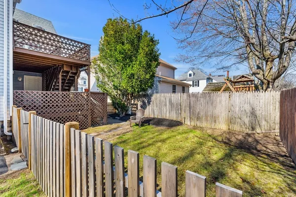 a view of a house with a small yard and wooden fence