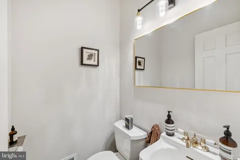 a bathroom with a toilet a sink and mirror