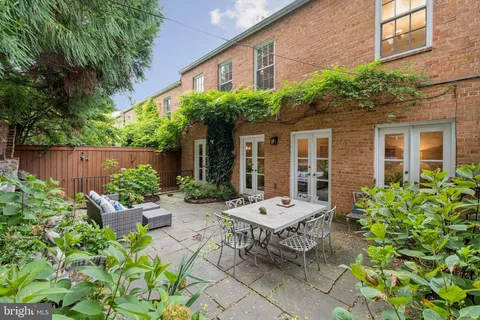 a view of a sitting area with brick wall and potted plants