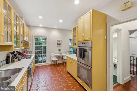 a kitchen with stainless steel appliances a stove top oven a sink and cabinets