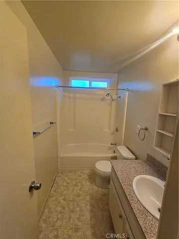 a bathroom with a granite countertop sink mirror vanity and toilet