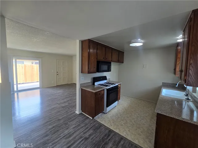 a kitchen with granite countertop a stove and a wooden floor
