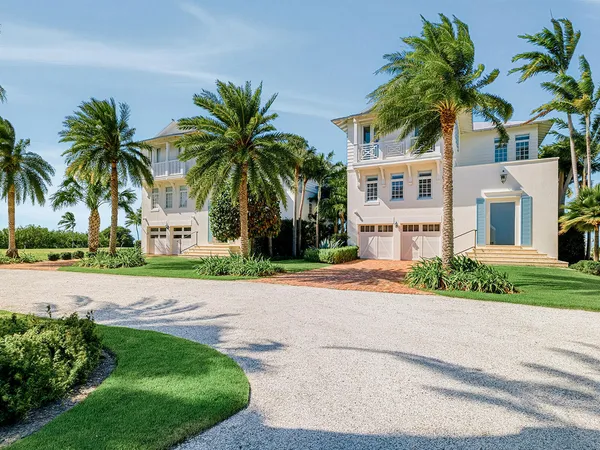 front view of house with a yard and palm trees