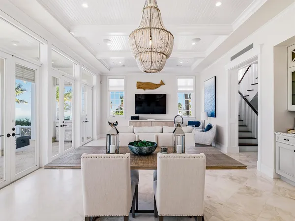 a living room with furniture a flat screen tv and a chandelier