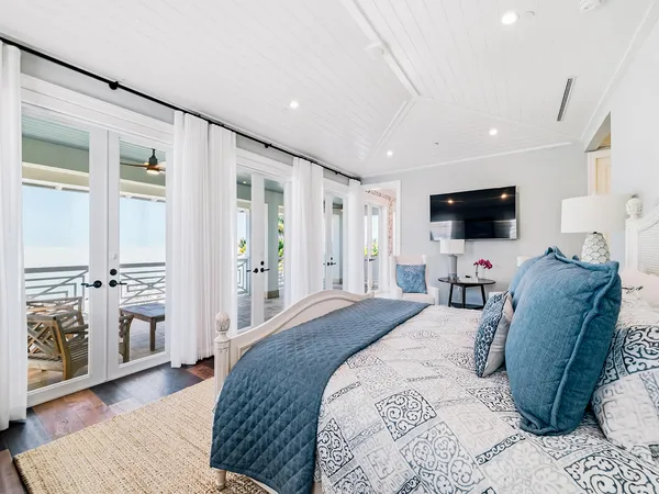 a large bedroom with a bed and wooden floor