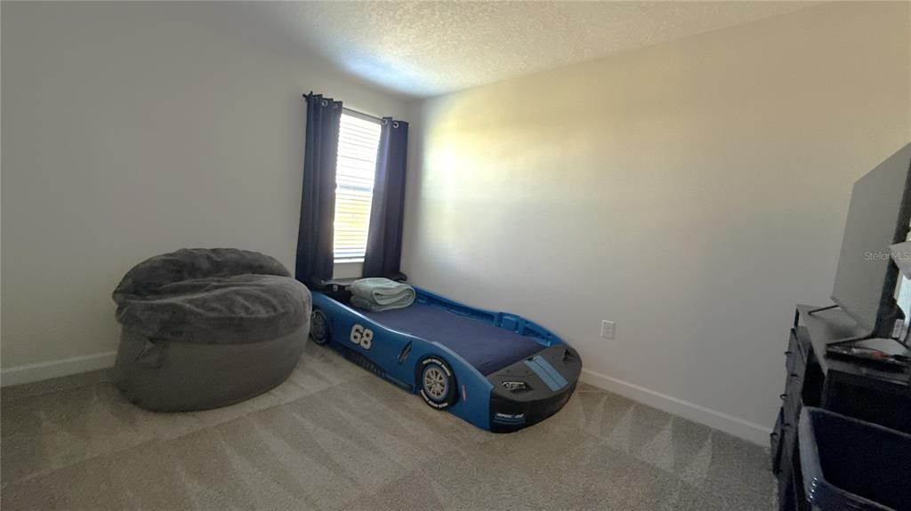 1055 Blackwolf Run Road Davenport, FL 33896 - Photo 11 of 23 a room with a bed and a mirror