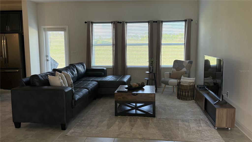 1055 Blackwolf Run Road Davenport, FL 33896 - Photo 4 of 23 a living room with furniture and a flat screen tv
