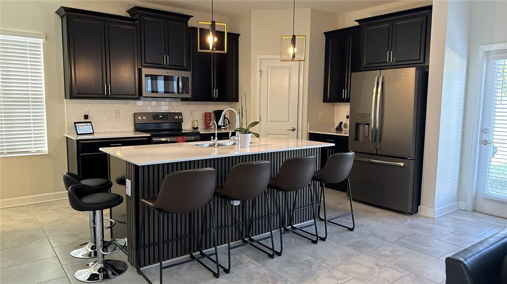 1055 Blackwolf Run Road Davenport, FL 33896 - Photo 5 of 23 a kitchen with stainless steel appliances granite countertop a sink refrigerator and cabinets