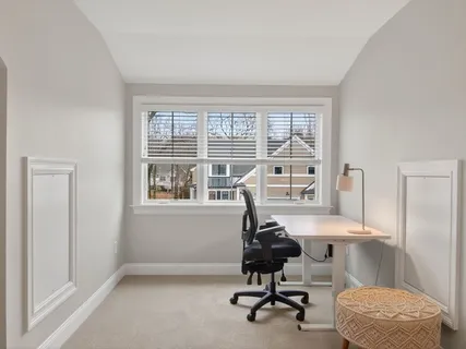 a view of a workspace with furniture and a window