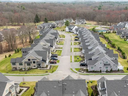 a aerial view of a house with a big yard and large trees