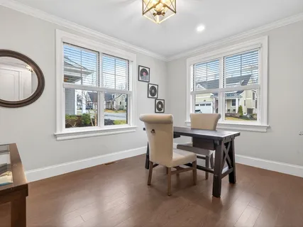 a dining room with furniture a chandelier and wooden floor