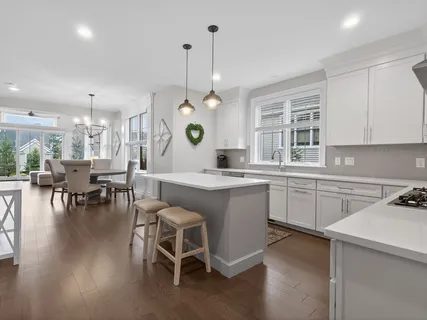 a kitchen with a dining table chairs sink and wooden floor