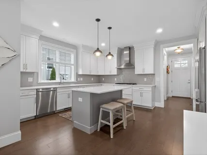 a kitchen with white cabinets and sink