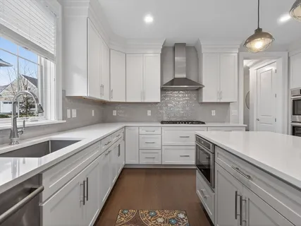 a kitchen with granite countertop white cabinets and white appliances