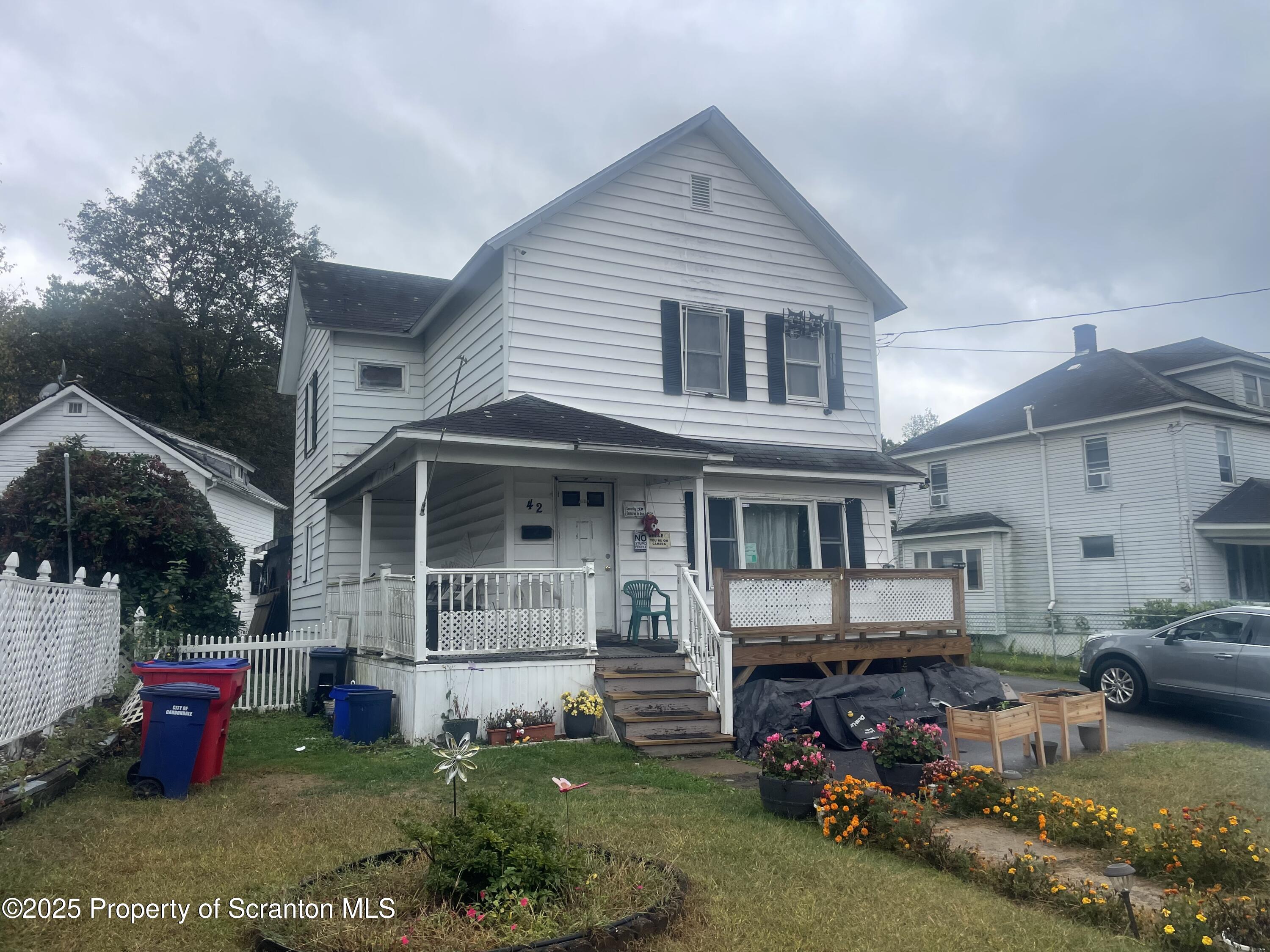 42 Upper Powderly Street Carbondale, PA 18407 - Photo 1 of 7 a front view of a house with a garden and porch