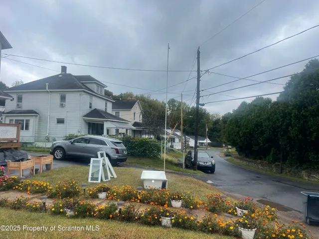 a view of a house with a yard chairs and fire pit