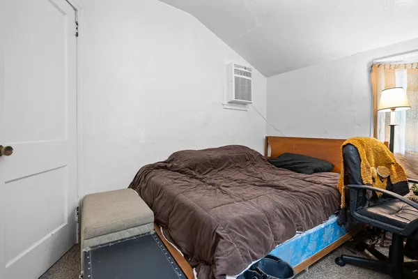 a bedroom with two beds and chair
