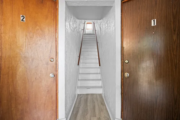 a view of a hallway with wooden floor and entryway