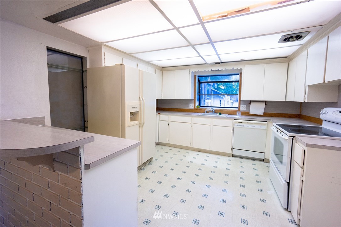6618 Willow Road Everett, WA 98203 - Photo 7 of 15 a kitchen with a sink a stove a refrigerator and cabinets
