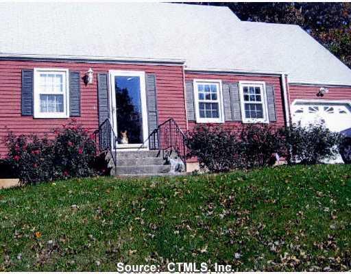 a view of a house with potted plants and a bench