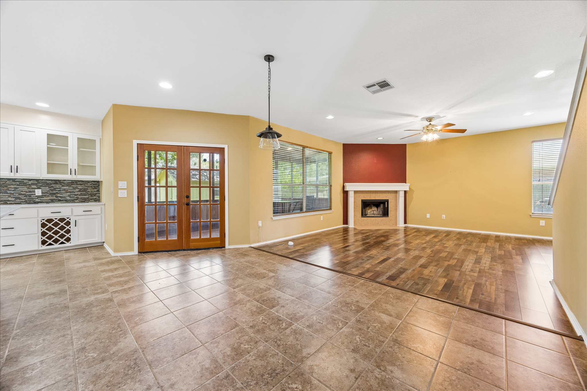 338 Spring Branch Loop Kyle, TX 78640 - Photo 9 of 36 A striking contrast of flooring highlights this living space with a cozy corner fireplace and custom built-in cabinetry.