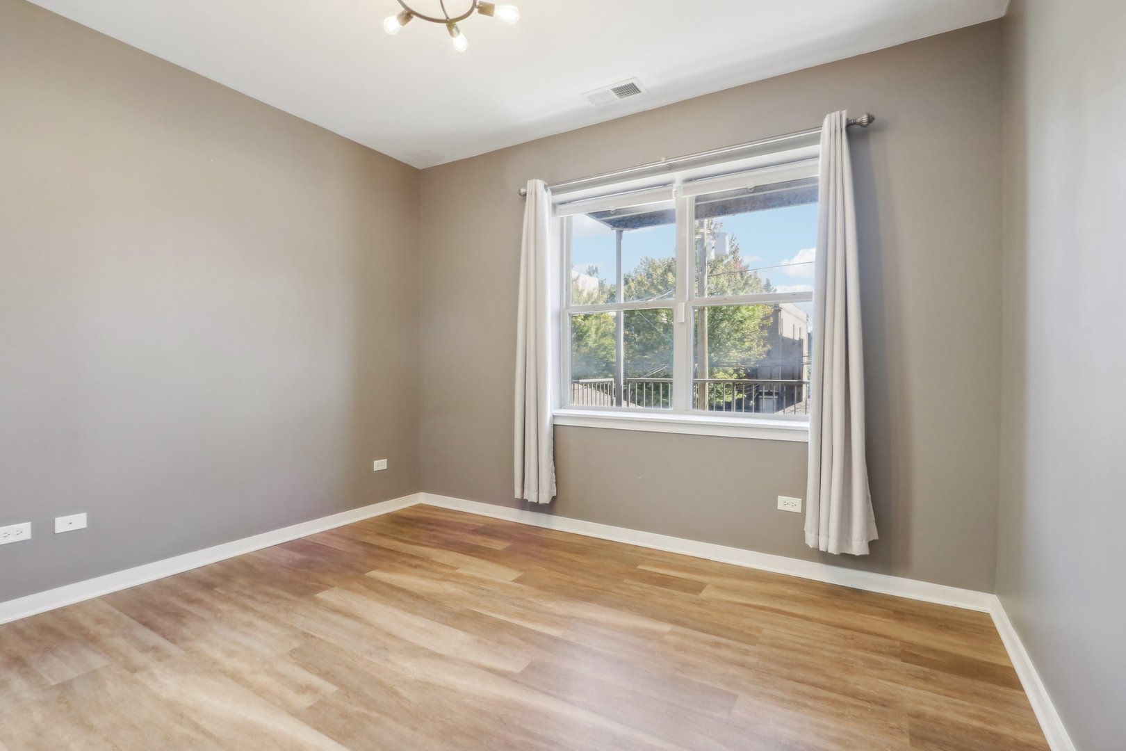 1033 South Lytle Street, Unit 201 Chicago, IL 60607 - Photo 28 of 35 a view of an empty room with wooden floor and a window