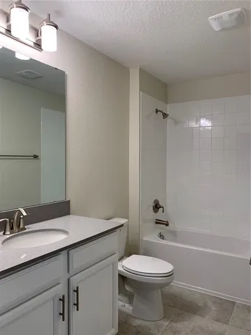 a bathroom with a granite countertop sink a toilet and shower