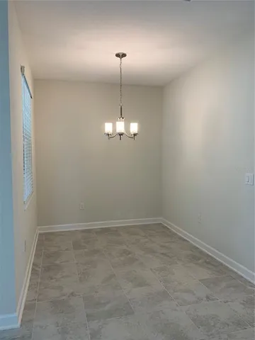 an empty room with chandelier fan