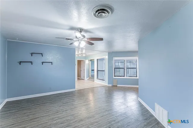 wooden floor in an empty room with a window